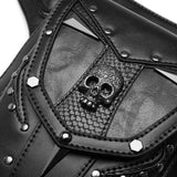 Close-up of a black gothic-style waist bag featuring a central skull emblem, textured faux leather panels, metallic studs, and a snakeskin-patterned accent.
